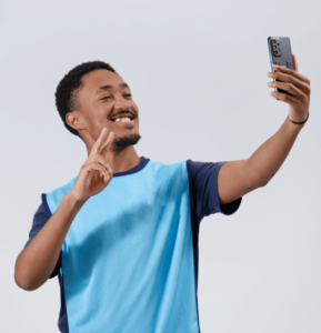 Jovem aprendiz negro de colete do CIEE segurando o celular para fazer selfie