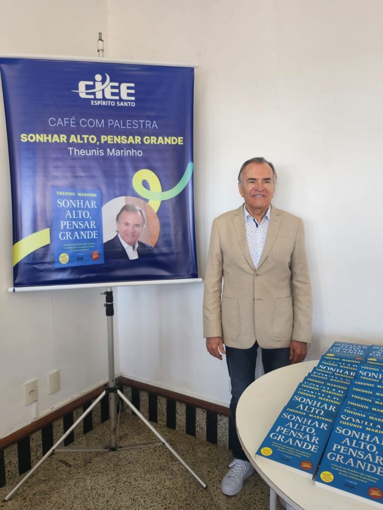 Autor e conselheiro do CIEE, Theunis Marinho posa ao lado de exemplares do livro “Sonhar Alto, Pensar Grande” durante palestra no Espírito Santo.