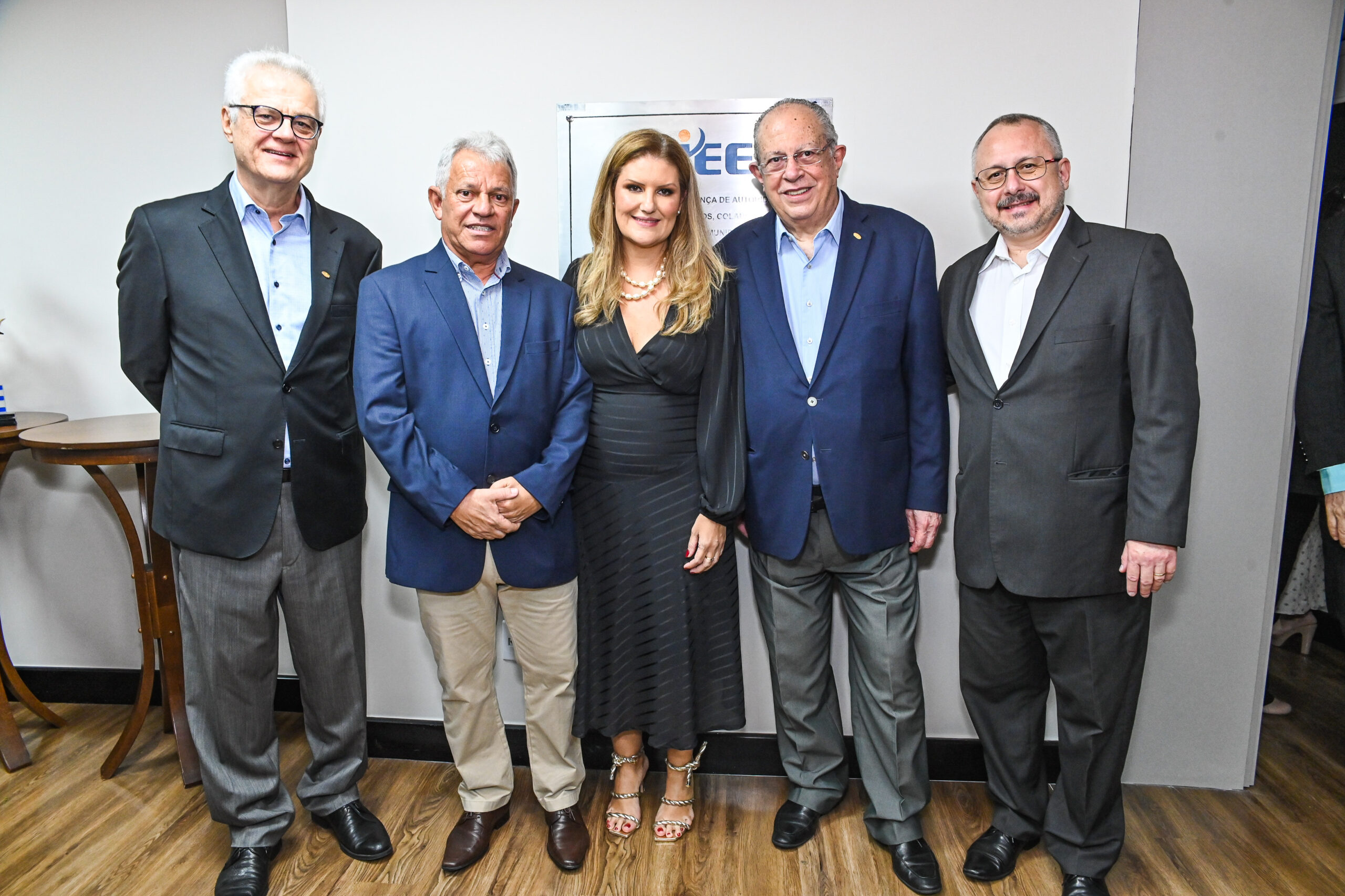 Treze pessoas posam sorrindo em frente a uma parede com palavras como "diversidade", "integração" e "CIEE".