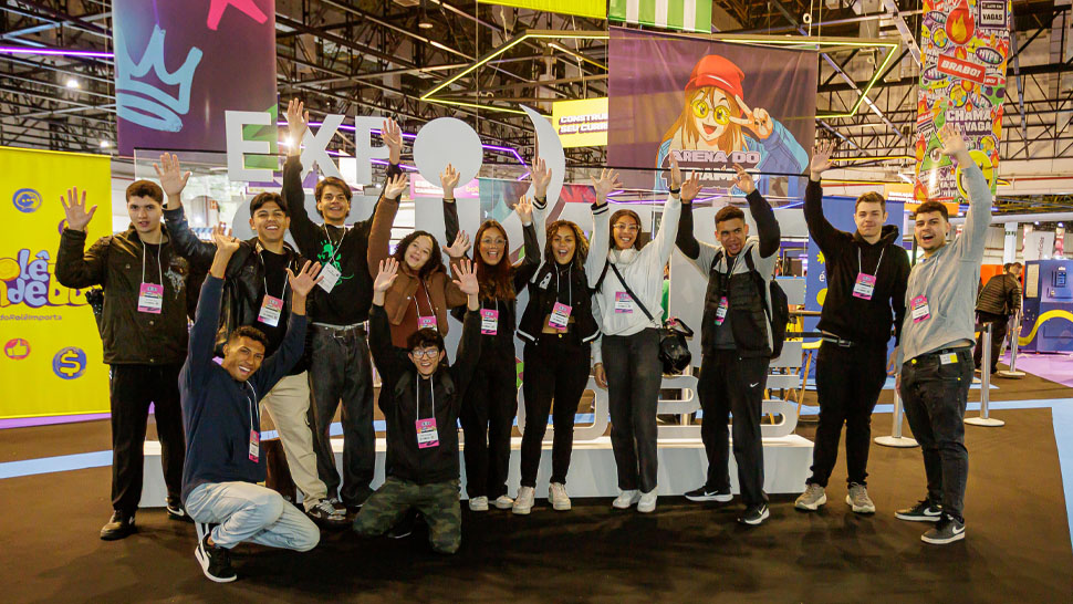 Diversos jovens posam em frente da imagem do logo do CIEE