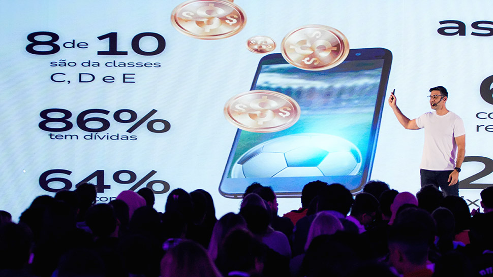 Rodrigo Dib, superintendente Institucional e de Inovação do CIEE, apresenta dados sobre finanças pessoais em um telão, diante de uma plateia atenta na EXPO CIEE 2025.