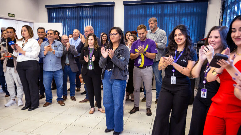 Dezenas de pessoas aplaudindo dentro de um espaço no CIEE de Piracicaba