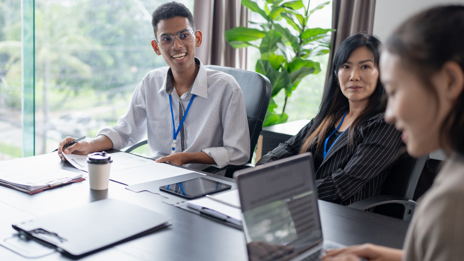 a imagem mostra três pessoas em um ambiente corporativo