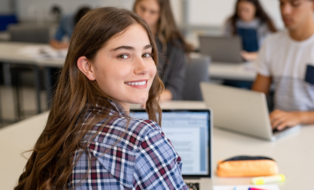 a imagem mostra uma menina na aula da faculdade
